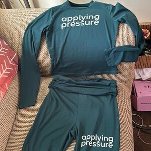 Green 2 Piece Set. Statement “APPLYING PRESSURE” on front of top and bottom